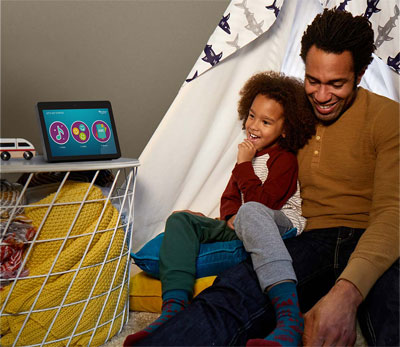   A boy and his father watching the Echo Show.  
